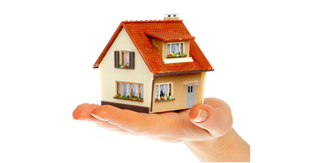 Ein Miniaturhaus auf einer ausgestreckten Hand - Fehler beim Immobilienverkauf