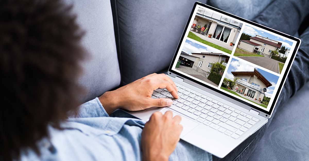 Ein Mann liegt mit Laptop auf dem Scho&szlig; auf der Couch und schaut sich Immobilien an | Immobilienbesichtigung