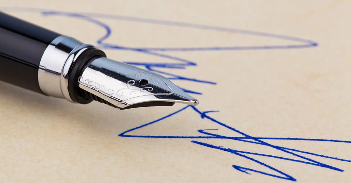 Eleganter F&uuml;ller, mit dem mit blauer Tinte eine Unterschrift geschrieben wird | Kaufpreiszahlung nach Notartermin