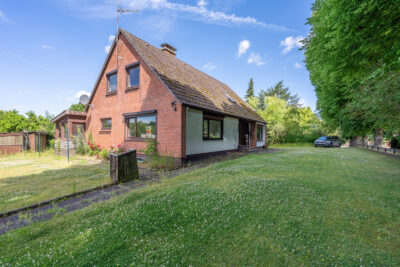Blick auf das Haus mit Gewächshaus und Garten