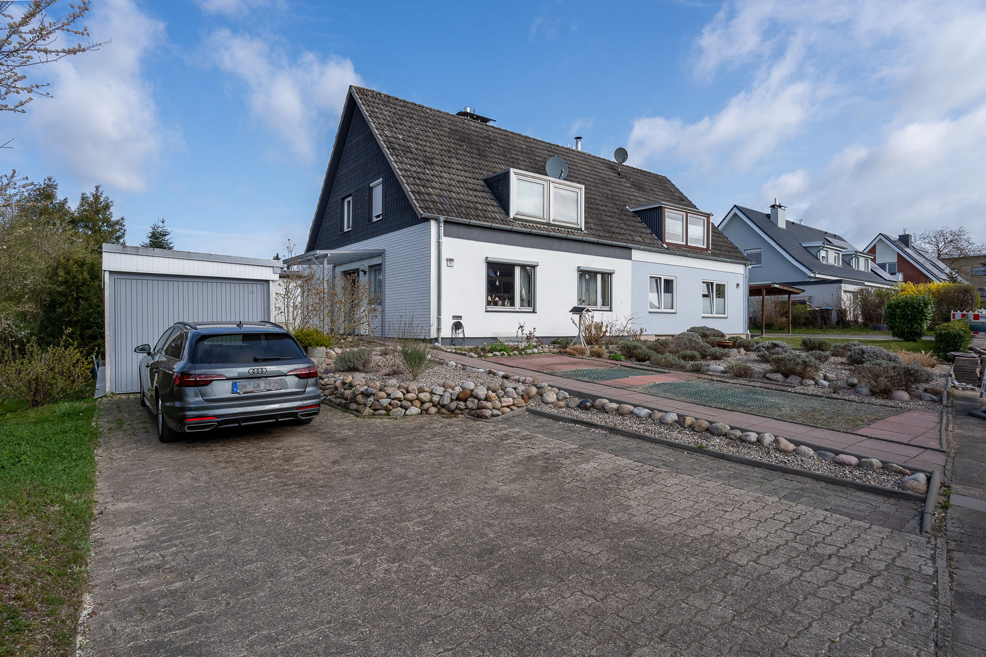 Hausansicht von der Zuwegung - Ansprechende Doppelhaushälfte, aufgeteilt in zwei Wohneinheiten und in beliebter Lage von Eutin